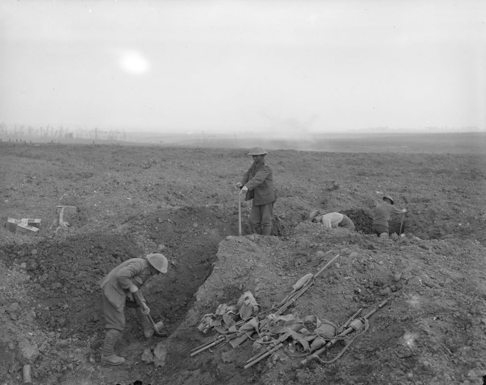 New Zealanders digging trenches out of shell craters. Note the kit of two soldiers lying nearby. September 1916.